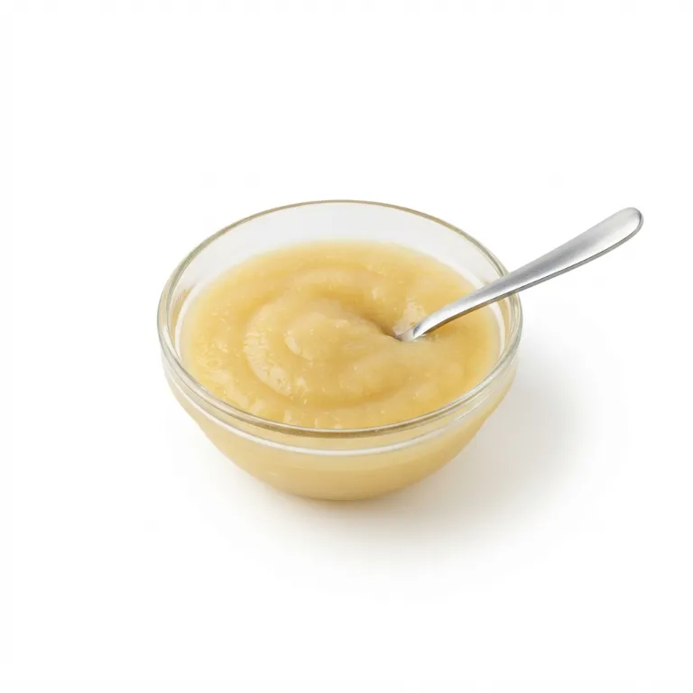 Petit bol rempli de compote de pommes avec une cuillère