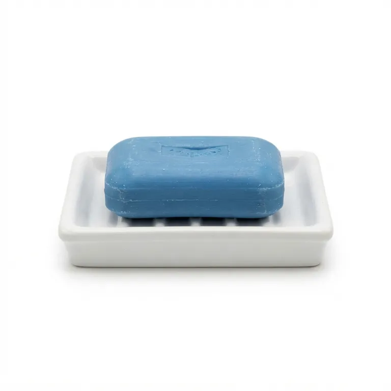 Savon solide rectangulaire bleu posé sur un porte-savon